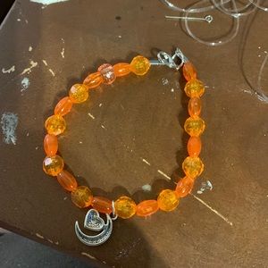 Orange anklet with a moonheart charm.